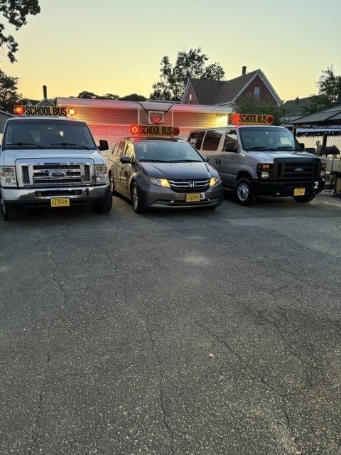 RMJ Transportation LLC fleet — school transport vans parked in a row